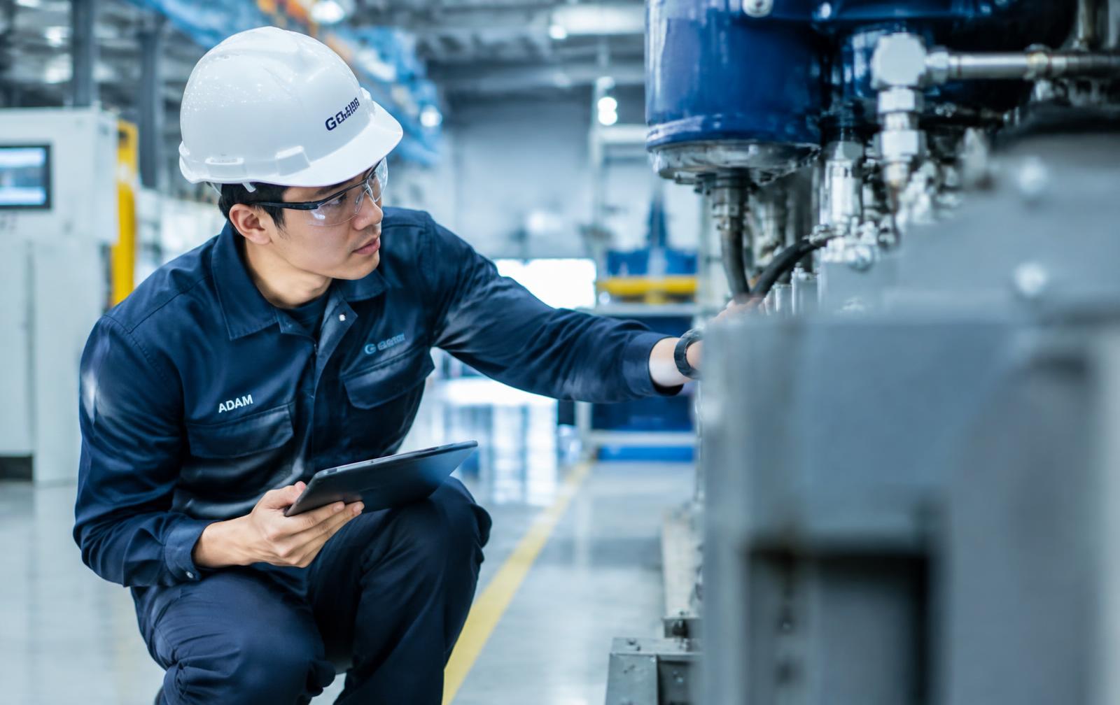 Engineer inspecting industrial machinery in a Malaysian factory